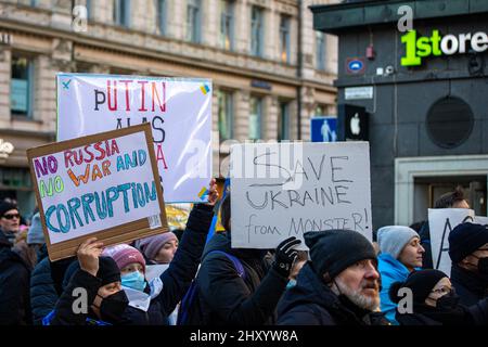 Demostratori con segni di protesta contro l'invasione russa dell'Ucraina su Aleksanterinkatu a Helsinki, Finlandia Foto Stock