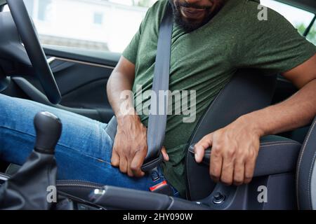 Primo piano della cintura di sicurezza con chiusura per auto del conducente maschile prima di partire per Journey Foto Stock
