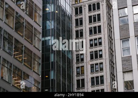 Edifici con pareti a specchio di vetro situati sulla strada della città moderna Foto Stock