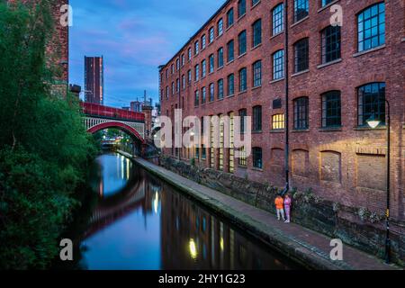 Castlefield edifici industriali lungo il fiume durante l'ora blu a Manchester, Inghilterra Foto Stock