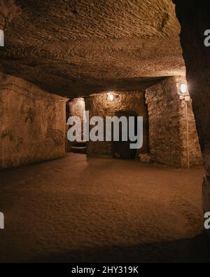 Colpo verticale di una città sotterranea o corridoio catacomba wirth pareti di pietra e ingressi Foto Stock