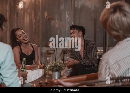 Gruppo di giovani amici che si godono il pasto e celebrare l'amicizia in pub e ristorante Foto Stock