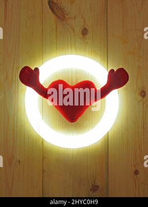 Cuore morbido con due mani isolate su sfondo rustico in legno Foto Stock