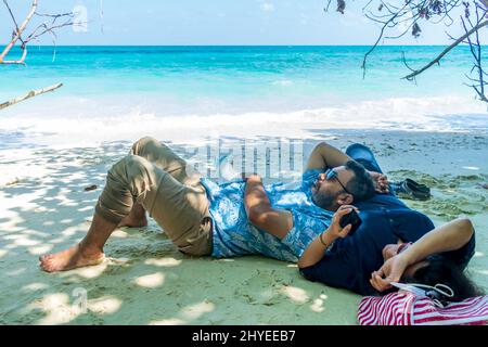 Una coppia rilassante sulla spiaggia, Havelock Island, Andaman, India Foto Stock