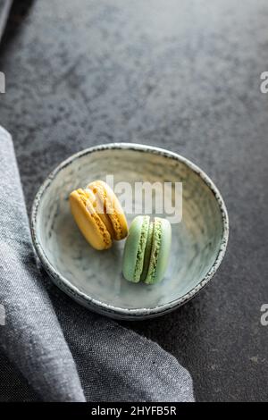 Macaron dolci e colorati. Macaroni francesi tradizionali. Dessert gustoso in ciotola. Foto Stock
