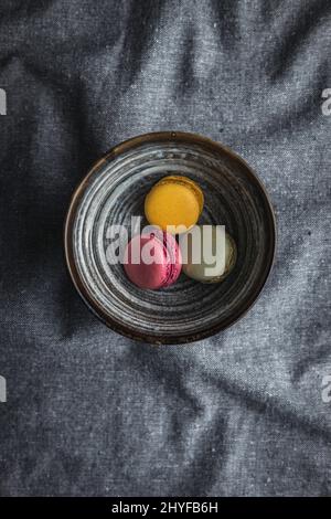 Macaron dolci e colorati. Macaroni francesi tradizionali. Dessert gustoso in ciotola. Vista dall'alto. Foto Stock