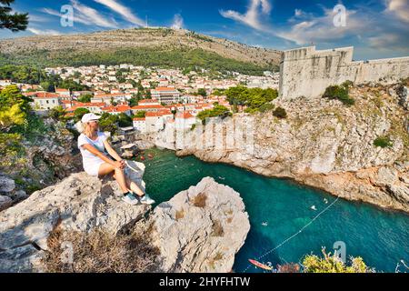 Paesaggio urbano di Dubrovnik con Fort Bokar in Croazia di Dalmazia. Architettura veneziana dell'UNESCO. Donna in cima alla fortezza di Lovrijenac, sopra il porto occidentale Foto Stock