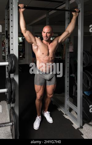 Ritratto di un giovane uomo fisicamente adatto che mostra il suo corpo ben addestrato - Bodybuilder atletico muscolare Foto Stock