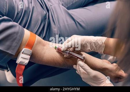 Tecnico di laboratorio che prende il sangue per la diagnosi di chimica del sangue Foto Stock