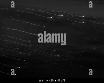 Sfondo astratto discendente. Immagine di pittura chiara che rappresenta le luci bianche che cadono nel cielo scuro Foto Stock