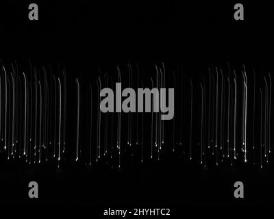 Sfondo astratto delle linee in discesa. Molte luci bianche che scendono su sfondo nero che rappresentano il concetto di caduta Foto Stock