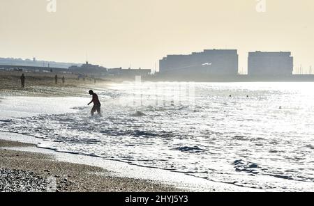 Brighton UK 7th Marzo 2022 - un nuotatore di prima mattina sulla spiaggia di Brighton in una bella giornata di sole con le previsioni del tempo caldo per diffondersi in tutta la Gran Bretagna nei prossimi giorni: Credit Simon Dack / Alamy Live News Foto Stock