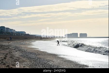 Brighton UK 7th Marzo 2022 - un nuotatore di prima mattina sulla spiaggia di Brighton in una bella giornata di sole con le previsioni del tempo caldo per diffondersi in tutta la Gran Bretagna nei prossimi giorni: Credit Simon Dack / Alamy Live News Foto Stock