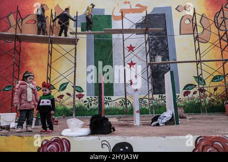 Idlib, Siria. 14th Mar 2022. Gli artisti dipingono un murale nella città di Idlib in vista del 11th anniversario della Rivoluzione Siriana. Credit: ANAS Alkharboutli/dpa/Alamy Live News Foto Stock