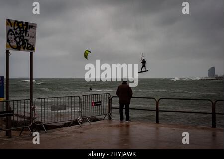 Barcellona, Spagna. 14 marzo 2022, Barcellona, Spagna: Un uomo guarda le persone che praticano il kitesurf durante una giornata di forti venti e tempeste di mare nella città di Barcellona. Credit: Jordi Boixareu/Alamy Live News Foto Stock