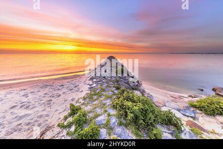 Tipica costruzione di un molo di basalto a Ijsselmeer vicino alla città di Hindeloopen nella provincia della Frisia al tramonto, in Olanda. Foto Stock