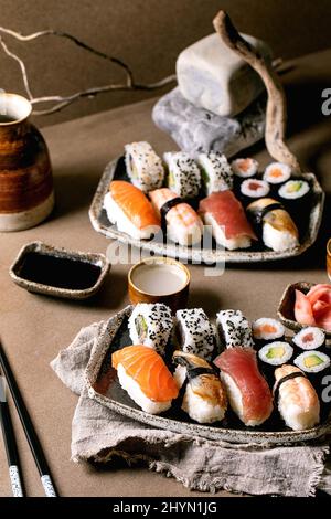 Panini con sushi per due. Sushi tradizionale giapponese e panini con salmone fresco, tonno, anguilla e gamberi sul riso. Servire su piatti con salsa di soia A. Foto Stock