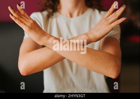 la giovane donna con le braccia incrociate al petto dimostra rompere il simbolo di bias della giornata internazionale delle donne iwd 8 marzo concetto di femminismo, pari di genere Foto Stock