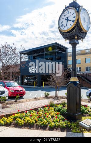 BELMONT, NC, USA-8 MARZO 2022: Orologio Street Corner, con vista laterale di Nellie's Southern Kitchen, NSK, dietro. Foto Stock