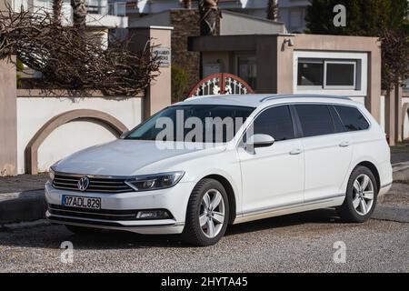 Side, Turchia -18 febbraio 2022: Volkswagen Passat bianco è parcheggiato sulla strada in una calda giornata autunnale sullo sfondo di una strada, negozio Foto Stock