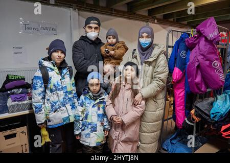 15 marzo 2022, Amburgo: La famiglia di rifugiati ucraini di Mohamed Jazara e Ludmilla Stupka con i loro figli Adam (l-r), Amin, Abdulla e Jasmina si trova nel negozio di abbigliamento di Rissen. Mohamed Jazara era già fuggito dalla Siria, poi dalla Crimea e, più recentemente, da Odessa. Ludmilla Stupka proviene da Donetsk. L'Arbeiter-Samariter-Bund (ASB) organizza il più grande negozio di abbigliamento di Amburgo attraverso il suo capitolo Amburgo-Mitte. La cosa speciale di questo progetto è che gli sfollati ucraini di guerra e i volontari di Amburgo riempiono e organizzano il negozio di abbigliamento insieme e cercano gli articoli adatti di Foto Stock