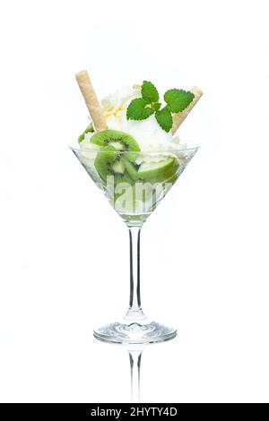 Una tazza di gelato al limone decorato con kiwi, coni e foglie di menta Foto Stock