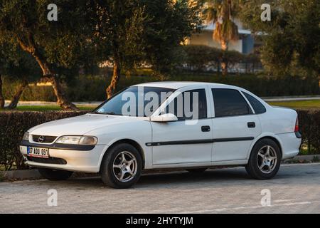 Side, Turchia - 18 febbraio 2022: White Opel Spectra è parcheggiato sulla strada in una giornata calda sullo sfondo di un parco Foto Stock