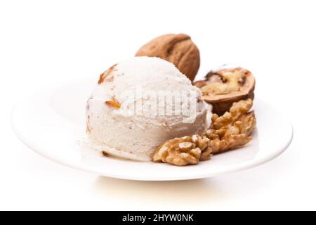 paletta per gelato di noce singola con noci su un piatto su sfondo bianco Foto Stock