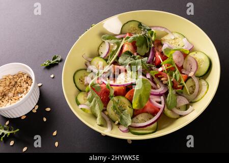 Vista ad angolo alto di insalata sana in ciotola su sfondo nero, spazio copia Foto Stock
