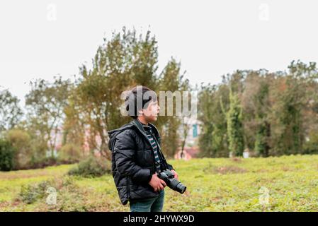 ritratto di un bambino fotografo nel bosco Foto Stock