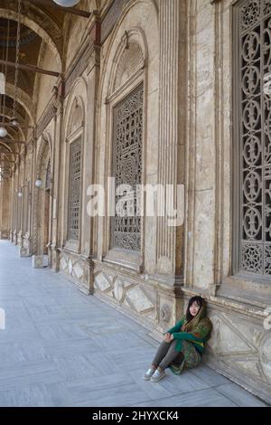 Colpo verticale di una donna cinese seduta di fronte alla moschea al Cairo, Egitto Foto Stock