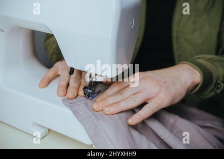 l'uomo sews su una macchina da scrivere in casa Foto Stock