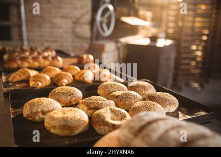 Vari panini e panini in teglia da forno disposti sul tavolo Foto Stock