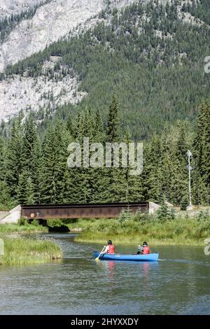 Due persone in canoa pagaia lungo il fiume Bow a Banff, Alberta, Canada, con il Monte Norquay sullo sfondo Foto Stock