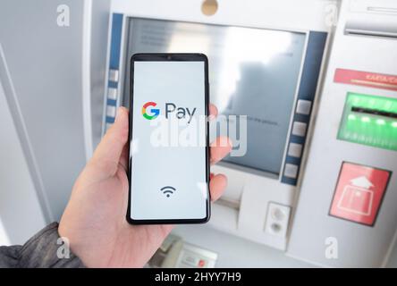 Wroclaw, Polonia - Nov 06, 2019: Uomo con smartphone con Google Pay logo. Google Pay è portafoglio elettronico sviluppato da Google. Foto Stock