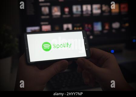 Wroclaw, Polonia - 27 GENNAIO 2022: Uomo con logo Spotify sullo schermo. Spotify è la piattaforma di streaming musicale più diffusa. Foto Stock