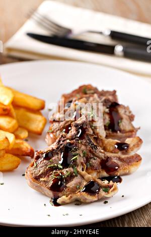 Costolette di agnello alla griglia con patatine fritte. Foto di alta qualità Foto Stock