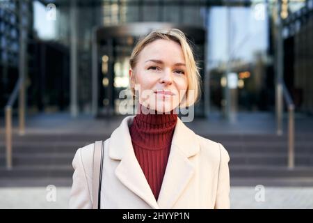 Donna d'affari caucasica di mezza età che guarda serio fotocamera. Bella ragazza allegra di 40-50 anni focalizzata sui successi del lavoro. Foto Stock
