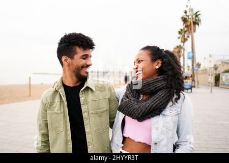 Giovane coppia afroamericana innamorata di divertirsi insieme all'aperto sulla spiaggia della città. Foto Stock