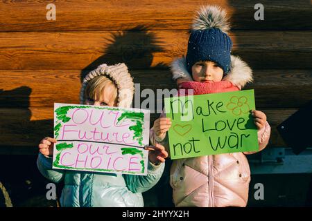 Giovani patrioti, attivisti per bambini. Piccole ragazze ucraine che chiedono di fermare la guerra sollevare banner con iscrizione fermare la guerra in Ucraina Foto Stock