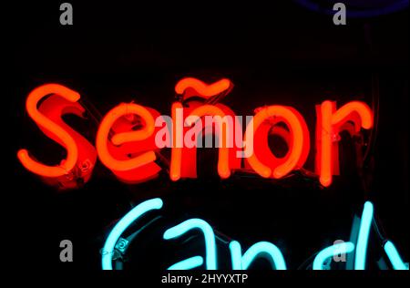 Un cartello al neon con la parola 'eñor' e la somiglianza di un uomo messicano che indossa un sonbrero brucia nella finestra di un negozio di caramelle a Santa Fe, New Mexico. Foto Stock