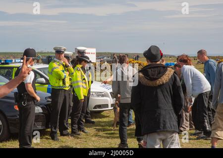 Polizia di fronte a ravers, rave illegale, Dale Airfield, maggio 2010, Pembrokeshire, Galles, Regno Unito, Europa Foto Stock