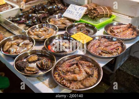 Vongole, gamberetti e altri frutti di mare venduti in un mercato umido a Hong Kong, Cina. Foto Stock