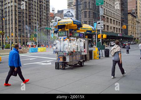 New York, NY, USA - Mar 15, 2022: Venditore vicino Flatiron edificio con vapore proveniente dal carrello come prodotti a base di carne sono tenuti caldi Foto Stock