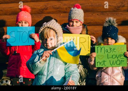 Giovani patrioti, attivisti per bambini. Piccole ragazze ucraine che chiedono di fermare la guerra sollevare banner con iscrizione fermare la guerra in Ucraina Foto Stock