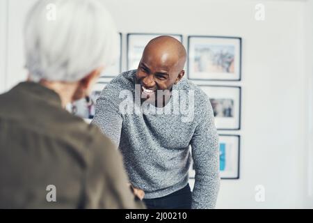 Sempre una buona atmosfera in ufficio. Scatto corto di due uomini d'affari allegri scuotendo le mani in accordo all'interno dell'ufficio durante il giorno. Foto Stock