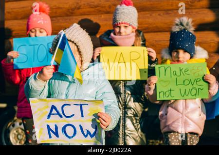 Giovani patrioti, attivisti per bambini. Piccole ragazze ucraine che chiedono di fermare la guerra sollevare banner con iscrizione fermare la guerra in Ucraina Foto Stock