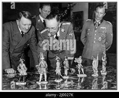 Adolf Hitler Fuhrer & dittatore della Germania nazista e Heinrich Luitpold Himmler Reichsführer dello Schutzstaffel (Squadrone di protezione; SS), e un membro di spicco del Partito nazista (NSDAP) della Germania ammirano una collezione di figure in porcellana che sono state realizzate in dettagliate uniformi di soldati storici. La fotografia di Heinrich Hoffmann ad Obersalzberg il 20 aprile 1944, che Heinrich Himmler presenta ad Adolf Hitler queste figure in porcellana di Allach per il suo 55th° compleanno. Porcellana di Allach Porzellan Manufaktur Allach è stato prodotto in Germania tra il 1935 e il 1945. Da lavoro forzato campo di concentramento Dachau Foto Stock