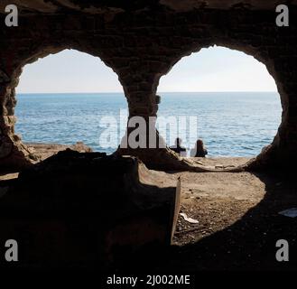 Persone in una cava di pietra circolare di fronte alla città di Calpe Foto Stock