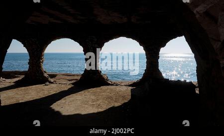 Cave di pietra di forma circolare di fronte alla città di Calpe Foto Stock